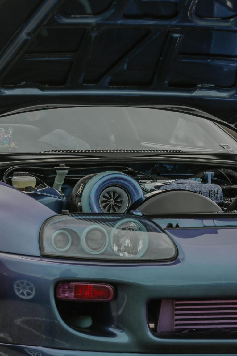 Detailed view of Toyota Supra engine with hood open, highlighting its performance features.