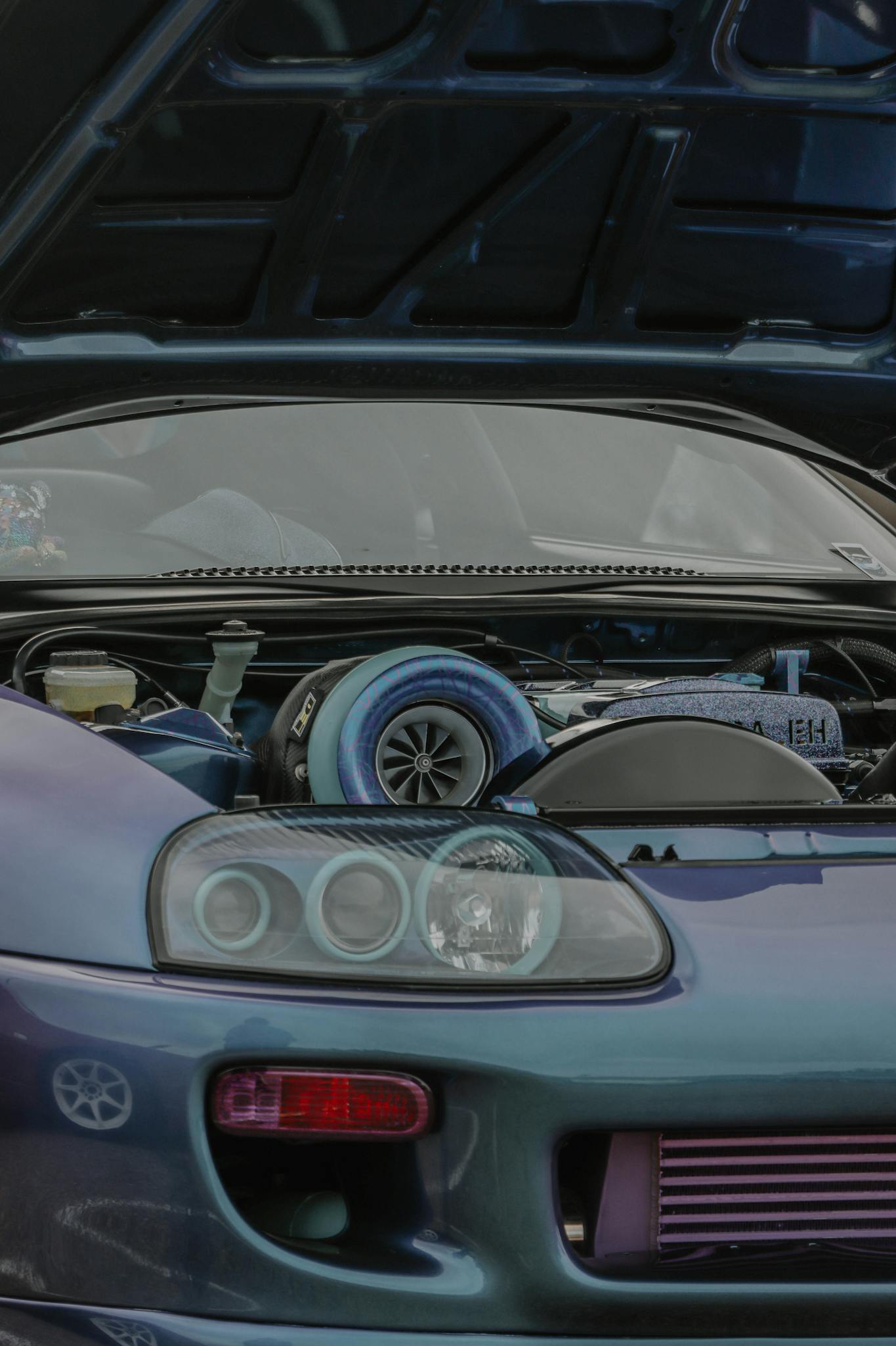 Detailed view of Toyota Supra engine with hood open, highlighting its performance features.